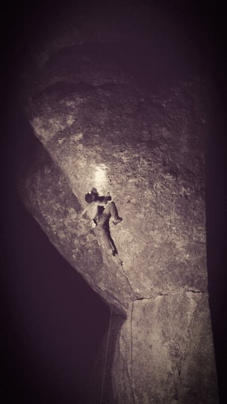 Climber on rock at night under a headlamp